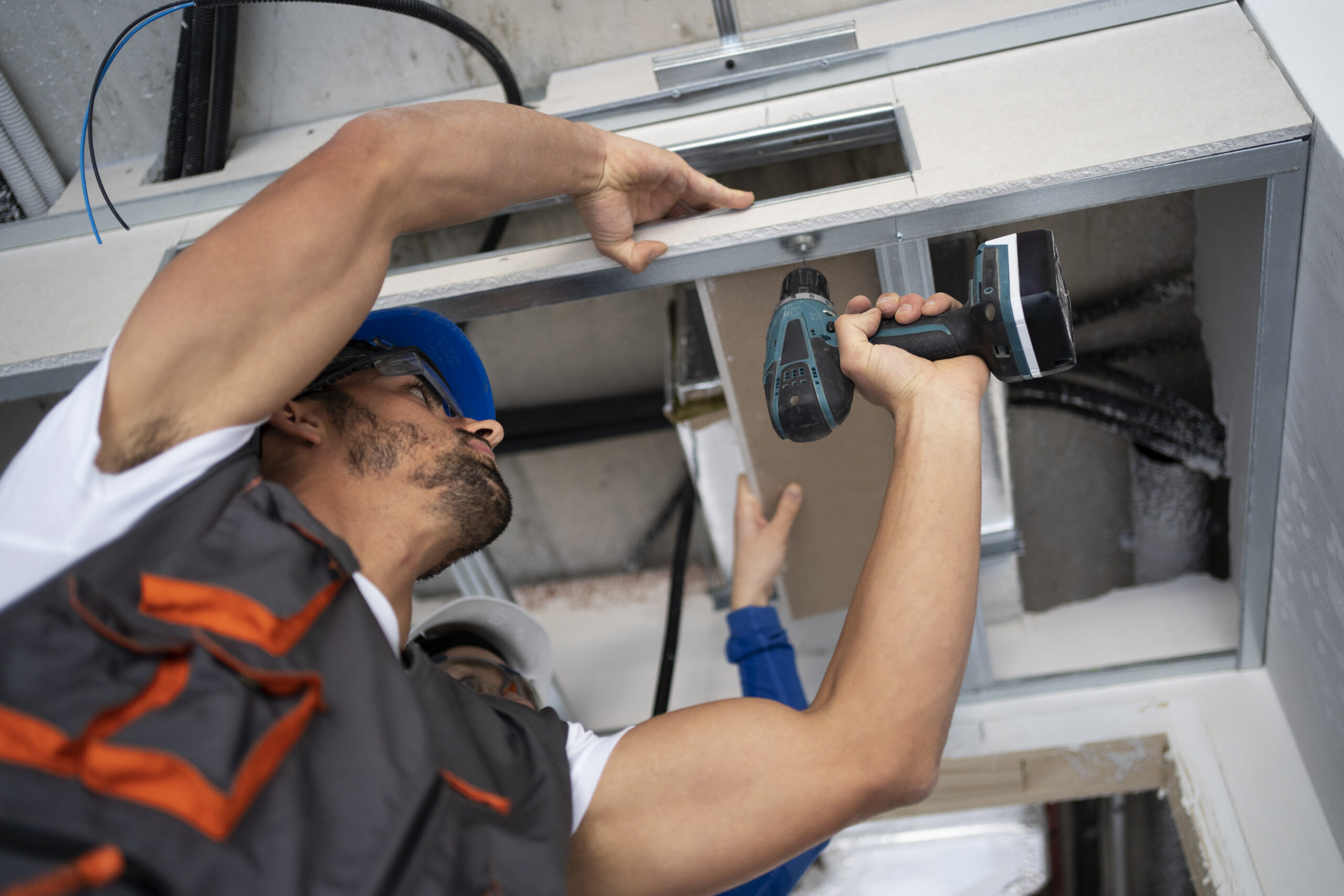 Technicien AB Sud Plomberie en pleine installation VMC Saint-Pierre dans une maison individuelle.<br />
